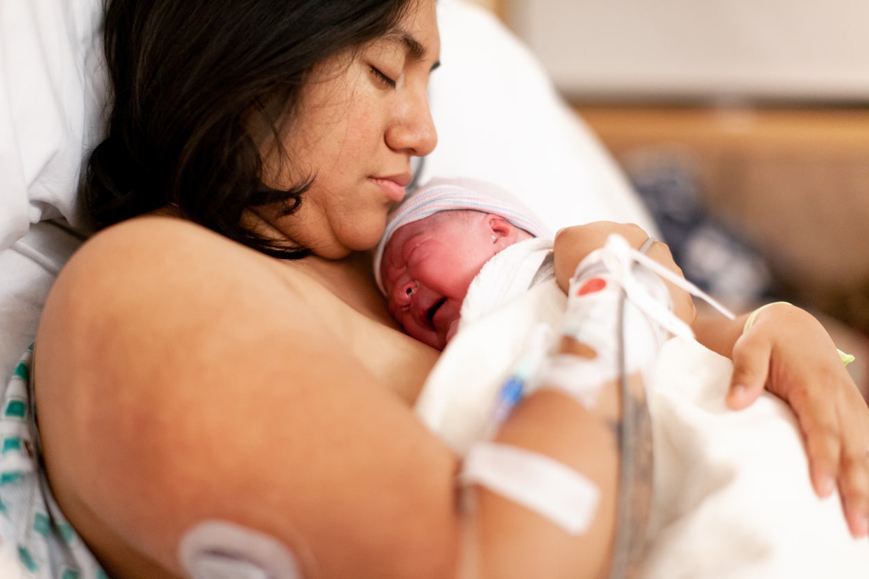 Mother holds newborn daughter. Labor complications image.